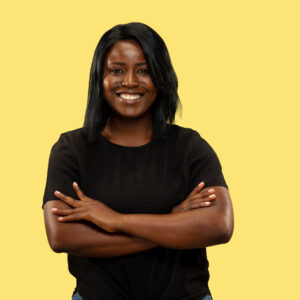 Young african woman isolated on yellow studio background, facial expression Young african-american woman isolated on yellow studio background, facial expression. Beautiful female half-length portrait. Concept of human emotions, facial expression. Standing crossing hands.
